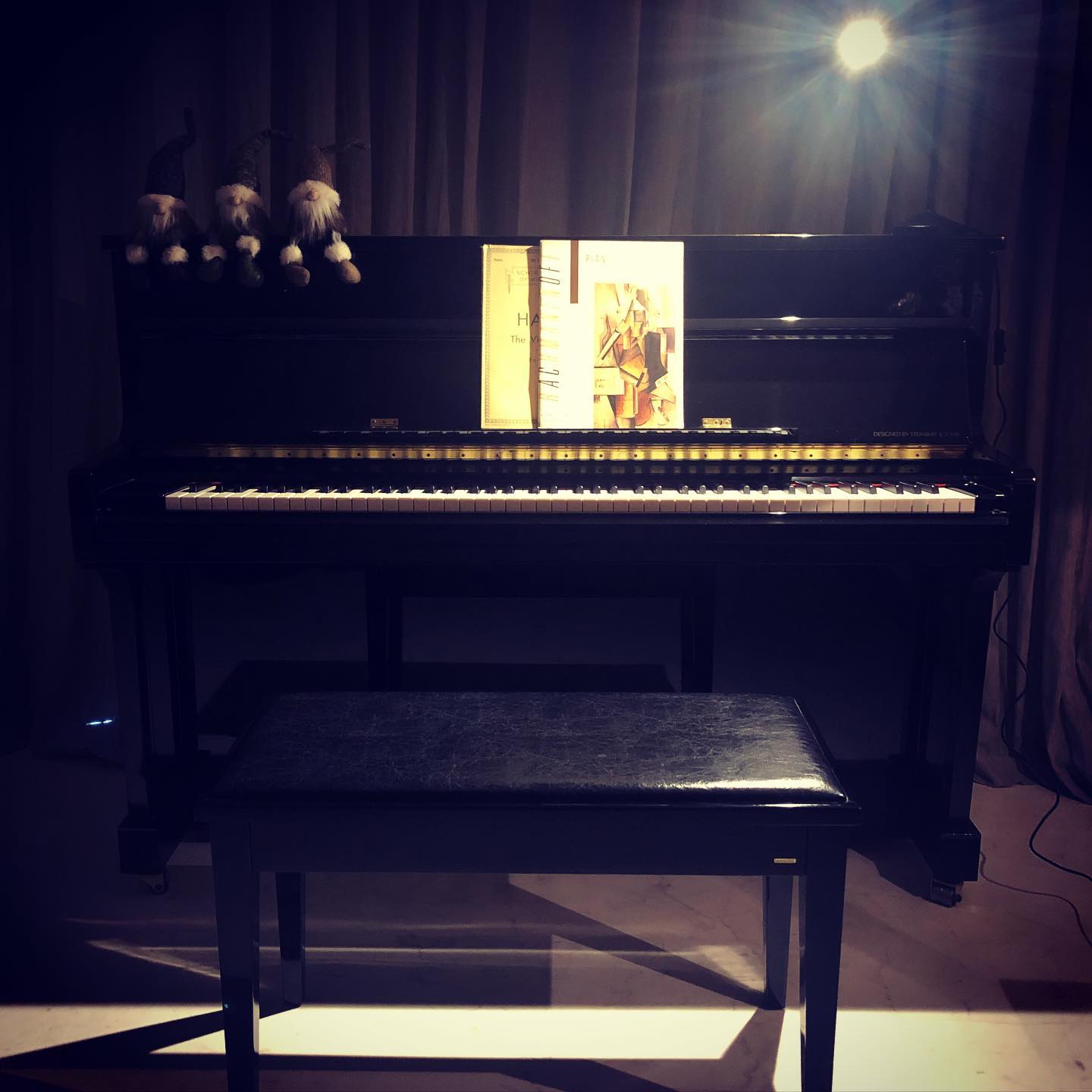 Upright piano under a spotlight